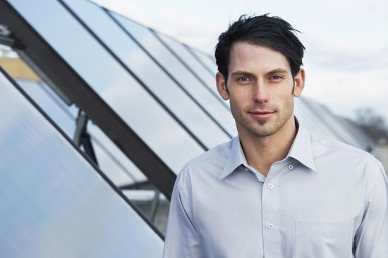 [Translate to English:] Mann steht vor Solarpanels