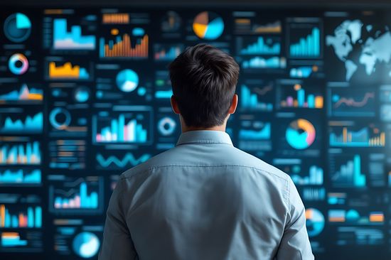 Geschäftsmann analysiert Datencharts und Finanzberichte an einer Wand. Unternehmensstrategie, datengestützte Entscheidungsfindung in einem modernen Geschäftsumfeld.