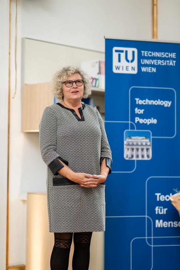 Sabine Seidler steht neben einem TUW-Rollup