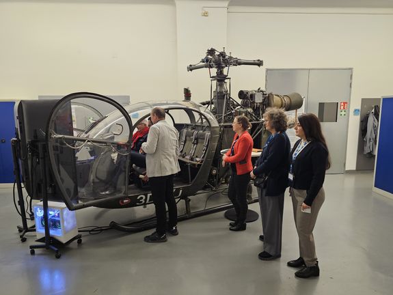 Personen stehen vor einen Hubschrauber und begutachten ihn 