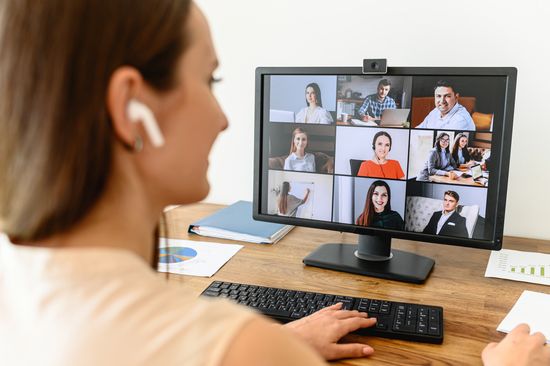 Studentin vor Bildschirm mit laufender Videokonferenz