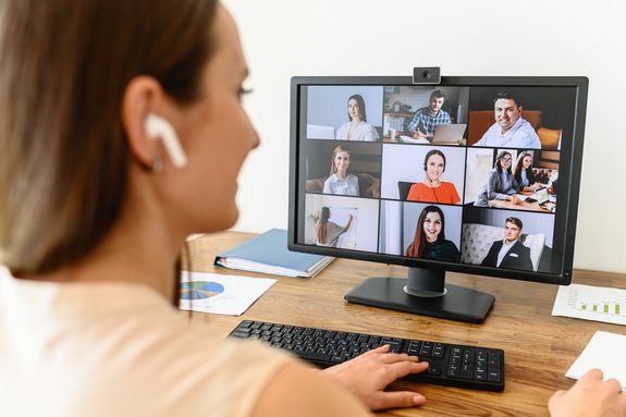 Studentin vor Bildschirm mit laufender Videokonferenz