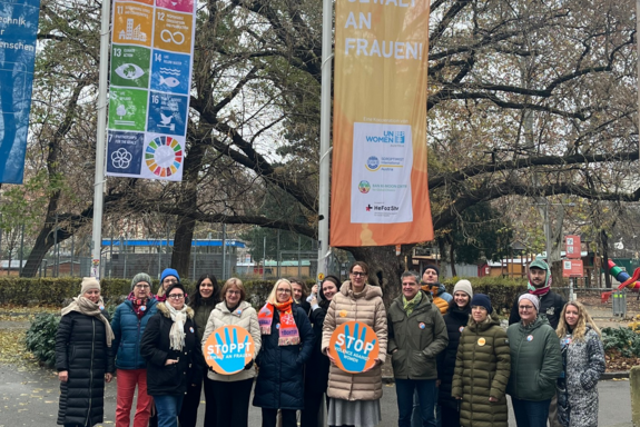Gruppenfoto vor den orangen Flaggen von Orange the World