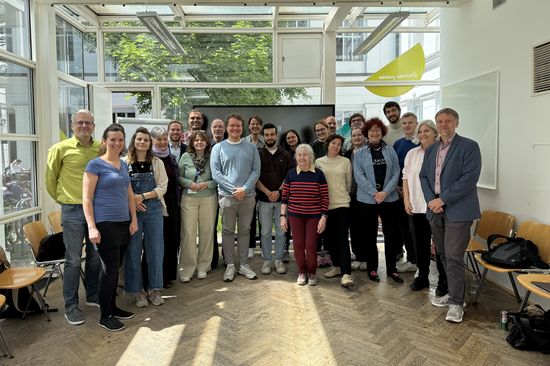 Gruppe Menschen stehend, lächelnd mit Blick zur Kamera 