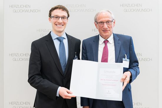 zwei Personen stehend. links Andreas Fuchsberger mit Urkunde, rechts