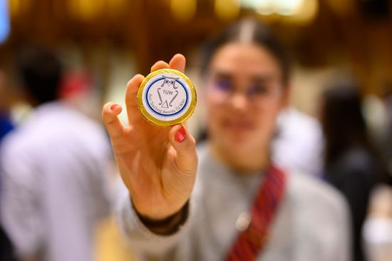 Person hält Schokotaler in die Kamera, Person und Hintergrund sind unscharf