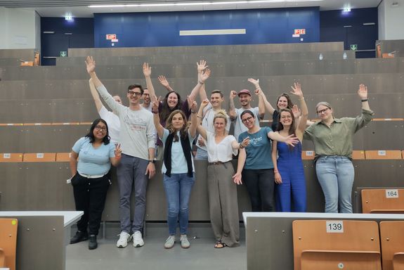 Menschen stehend in Hörsaal jubelnd