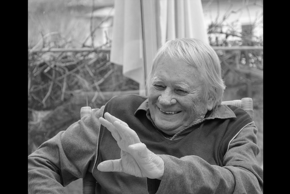 schwarzweiß Porträt Prof. Friedrich Moser, sitzend und lachend