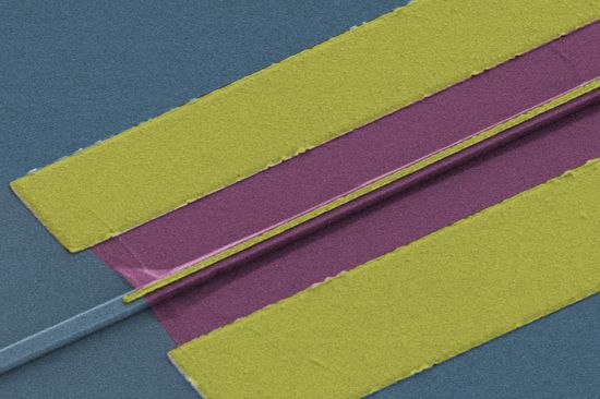 Durch einen dünnen Lichtwellenleiter (links) kommt das Signal, im etwa 2 Mikrometer schmalen Graphen-Streifen entsteht dadurch dann elektrischer Strom.