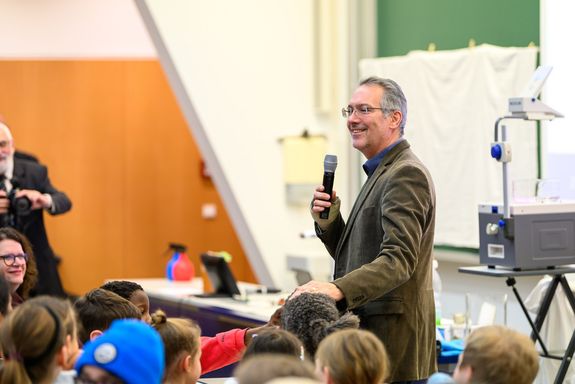 Mann in Anzug mit Brille und Mikro