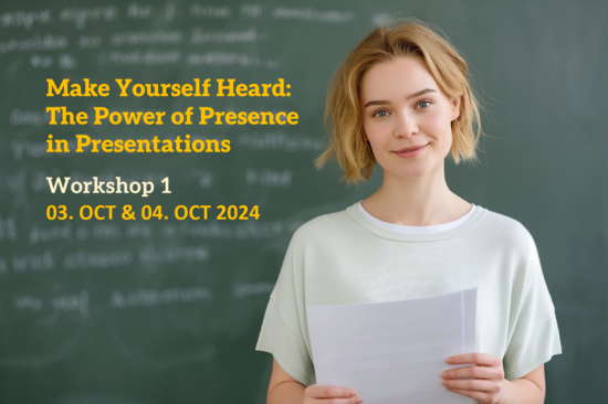 A person in a classroom is holding papers and looking confident and happy. There is a blackboard in the background filled with notes, but the image is blurry.