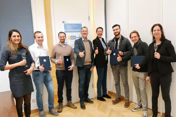 Gruppenbild der Preisträger_innen und TUW-Angehörigen. Daumen hoch oder mit Sektglas.