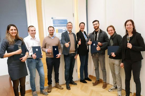 Gruppenbild der Preisträger_innen und TUW-Angehörigen. Daumen hoch oder mit Sektglas.
