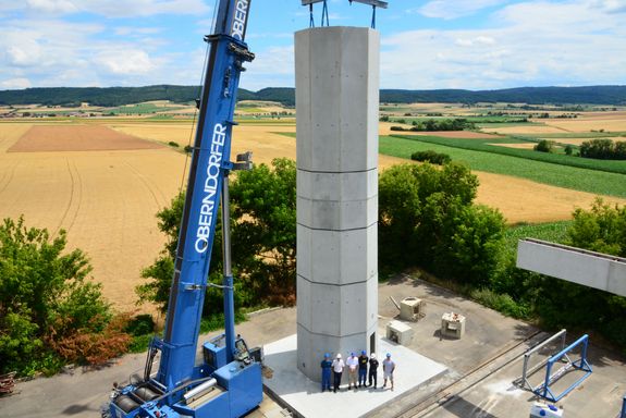 Die hohlen Beton-Doppelwandelemente werden mit Hilfe eines Krans exakt aufeinander gestapelt und dann vor Ort mit Beton ausgegossen.