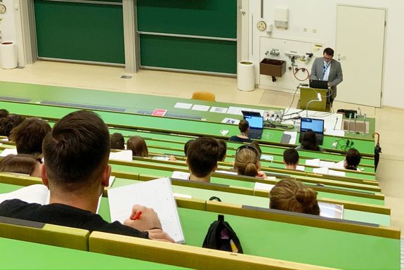 Hörsaal mit Studierenden und einem Vortragendem