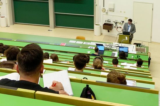 Hörsaal mit Studierenden und einem Vortragendem