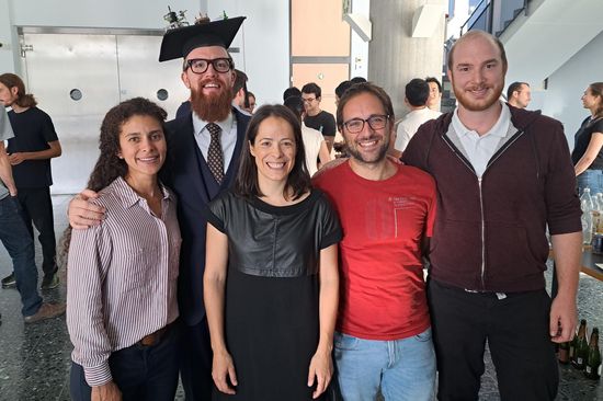 Nach der Verteidigung des Doktortitels ist auf dem Foto eine Gruppe von Forschern zu sehen, darunter der neue Arzt Jonathan Spring und seine Betreuerin Marta Gibert