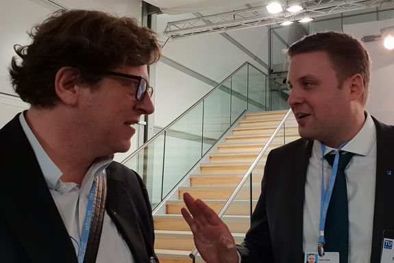Dr. Stefan Müller (left) talking to an exhibitor