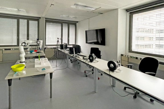 Labor: Pulte an der Fensterseite, in der Mitte Tisch mit Geräten und gelbem Behälter.