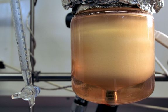 Glas mit Flüssigkeit, im oberen Bereich flockig trüb, unten flüssig transparent.