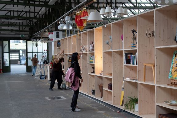 Ein raumgreifendes Holzregal dient als überdimensionaler Setzkasten und schafft nun eine visuelle Trennung des Kundenbereichs vom Sortierbereich