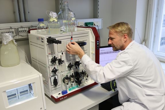 Oliver Spadiut vor einem technischen Gerät mit zahlreichen Drehknöpfen