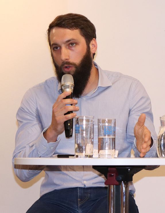 A close-up of Christoph Kirchberger speaking into the microphone.