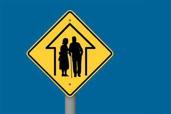 Ein gelbes Verkehrsschild mit der Darstellung zweier älterer Personen als Piktogramm. TU Wien blauer Hintergrund.