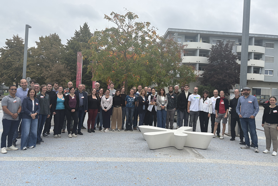 The photo shows about 40 people standing in a semi-circle.