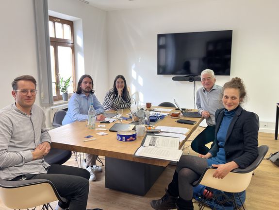 [Translate to English:] Daniel C. Rosenfeld in einer Besprechung mit 4 anderen Personen im München