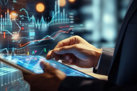 Businessman holding a tablet reviewing business data financial report