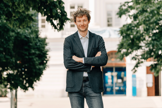 Dominik Wagner vor TUW-Hauptgebäude (Hintergrund unscharf).