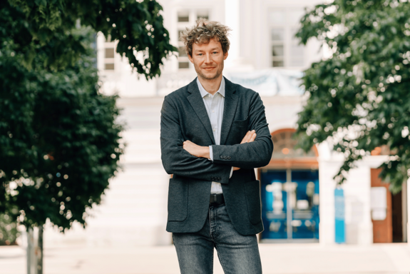 Dominik Wagner vor TUW-Hauptgebäude (Hintergrund unscharf).