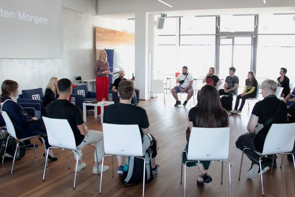 Vizerektorin Anna Steiger hält Begrüßungsrede vor den im Kreis sitzenden TUW-Lehrlingen.