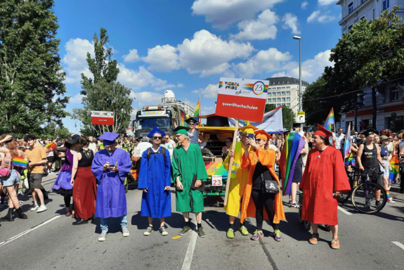 Regenbogenparade-Teilnehmer mit Plakat queer@hochschulen