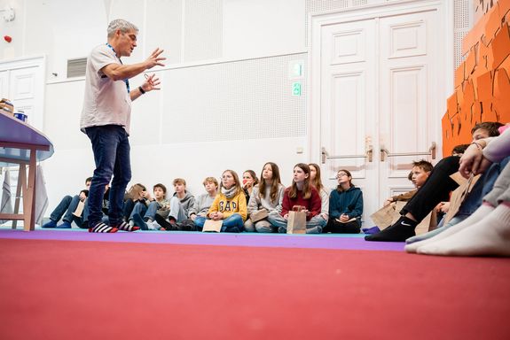 Michael Hoch begrüßt Schüler_innen in der Ausstellung.