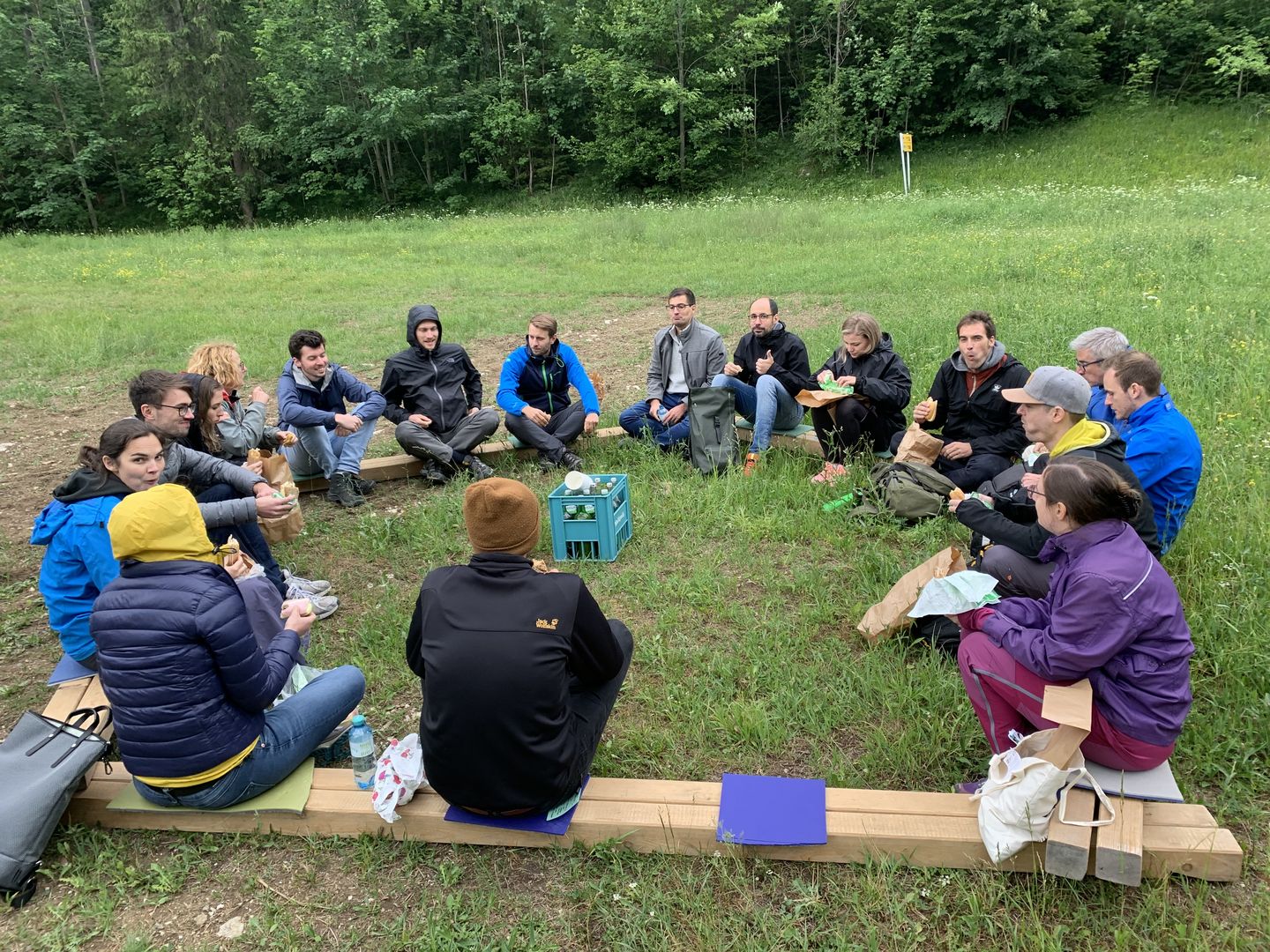 Participants sitting in circle outdoors having lunch