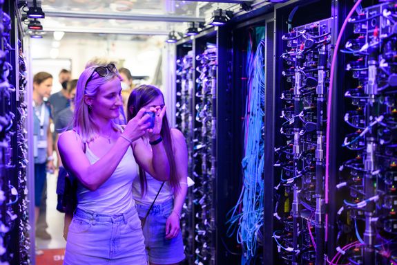 Zwei Frauen im Server-Gang des VSC4, die Fotos aufnehmen.