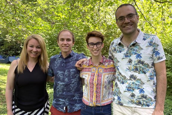 four people in front of trees