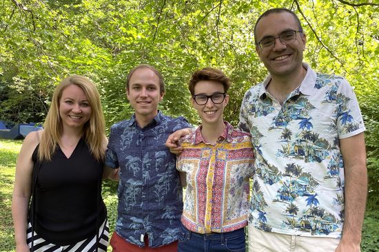 four people in front of trees
