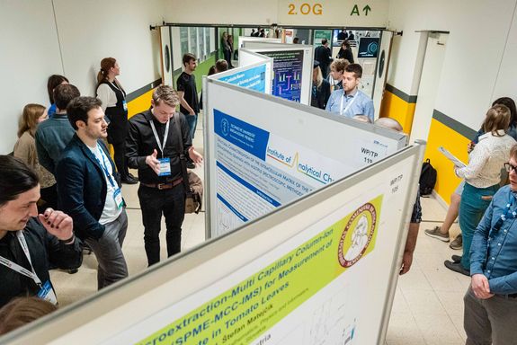 Posterwand in der Mitte des Raumes, die von den Besucher_innen betrachtet wird