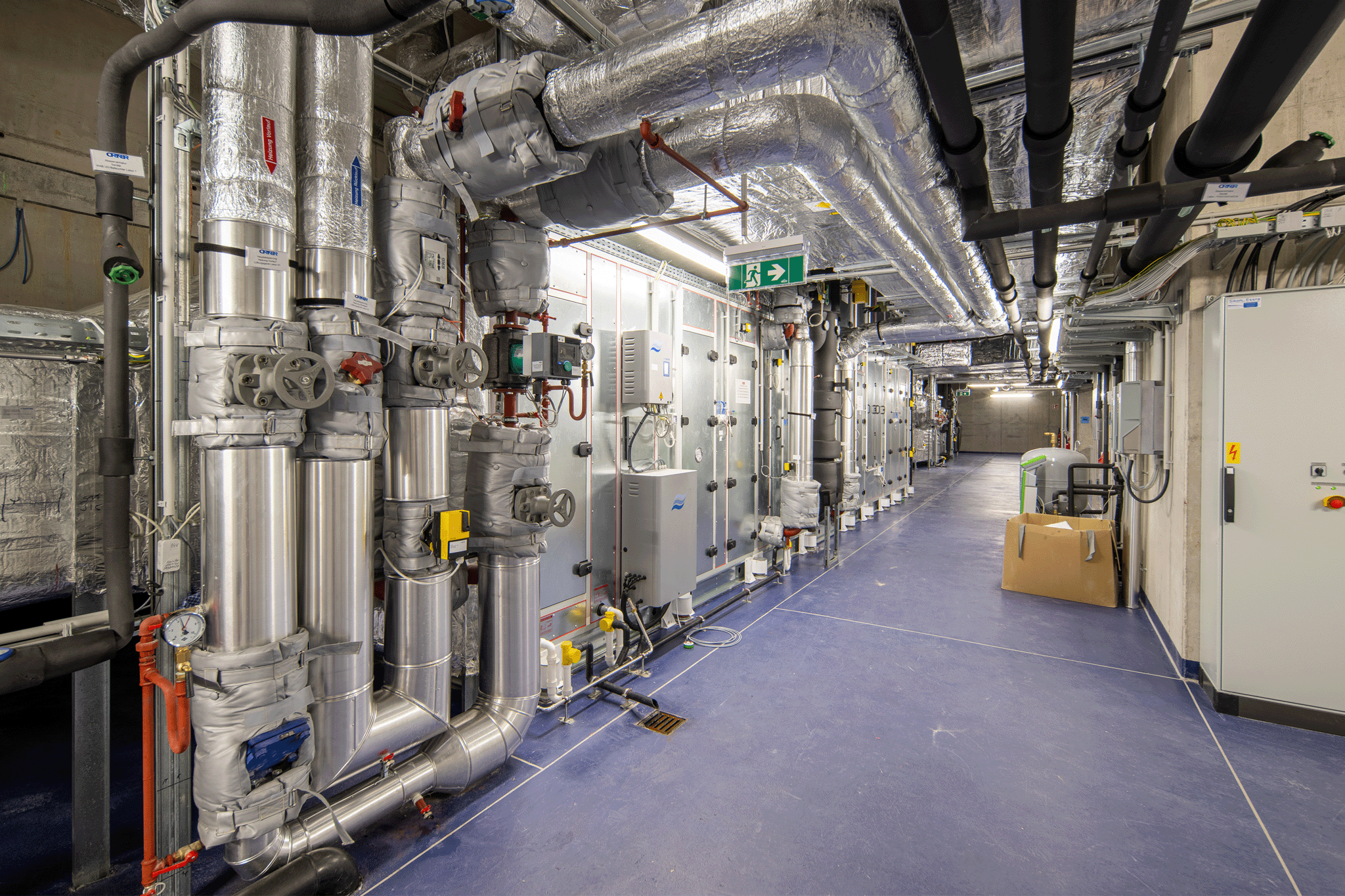 Dicke Metallröhren an Wand und Decke, Haustechnik, blauer Boden
