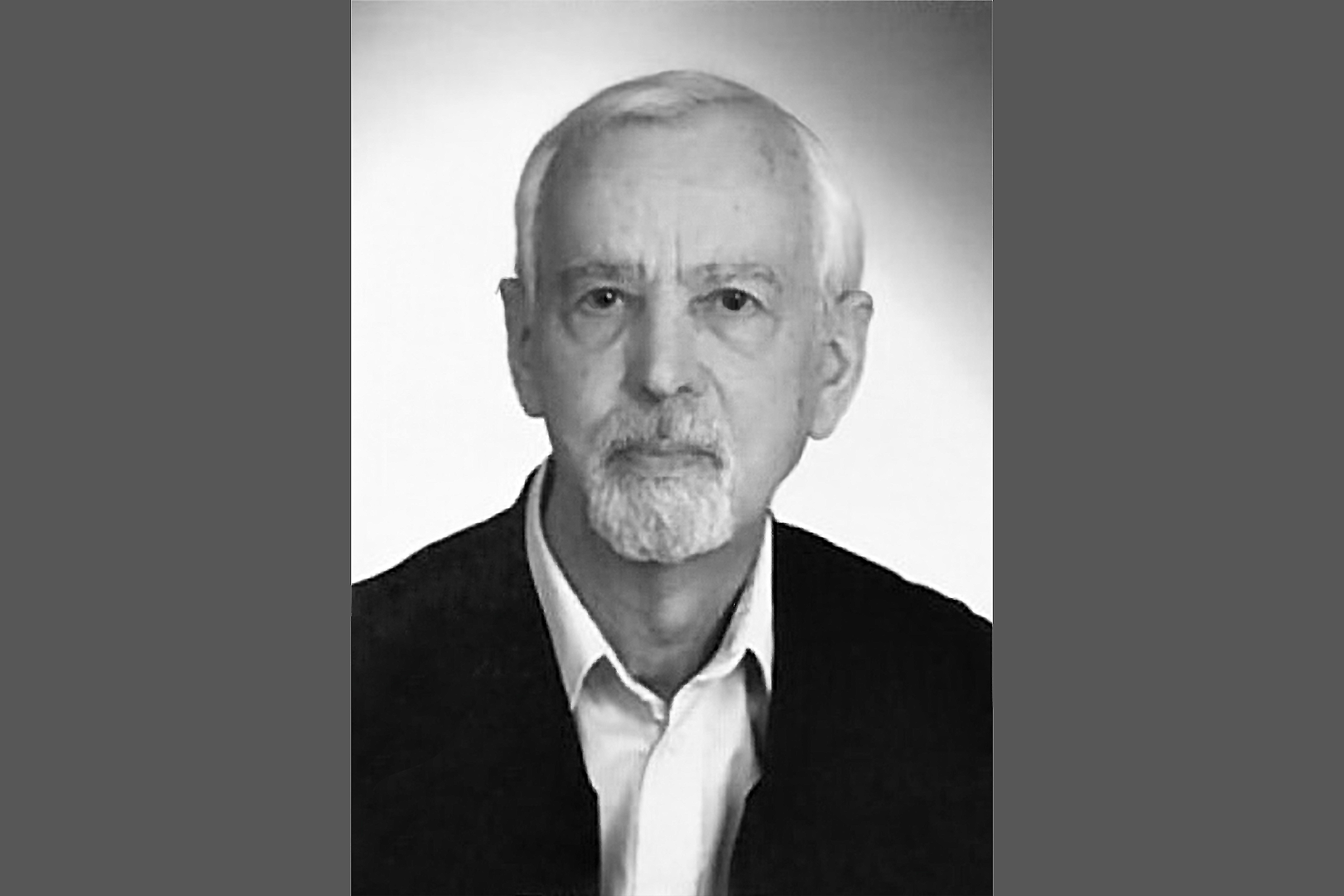 Schwarz-weiß-Porträt von Prof. Brockhaus, die Seitenteile sind grau. Er trägt ein schwarzes Sakko und ein weißes Hemd.