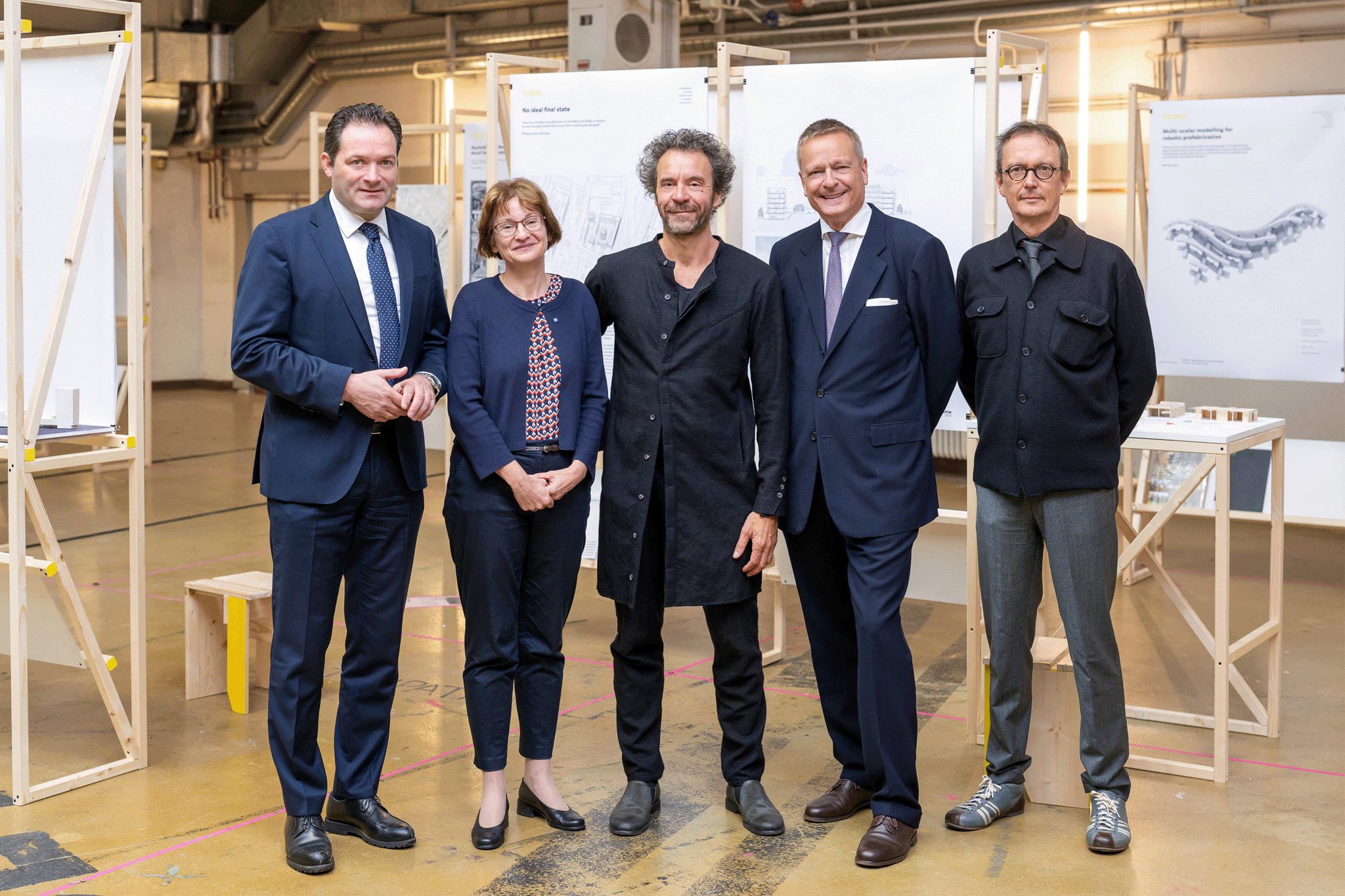 Gruppenbild mit fünf Personen in Businesskleidung, in blau und schwarz gehalten.