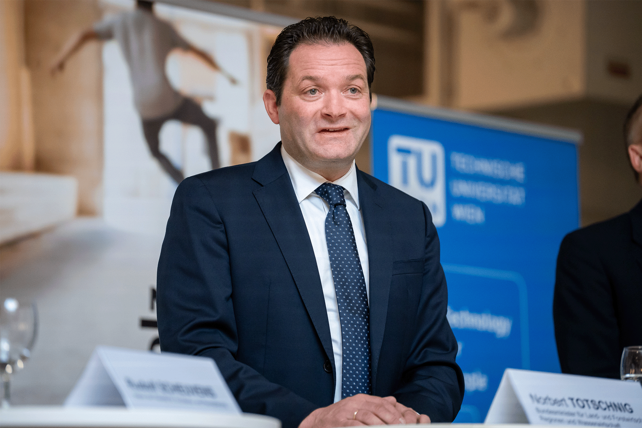 BM Totschnig mit dunikelblauem Jackett, weißem Hemd und Krawatte am Rednerpult.