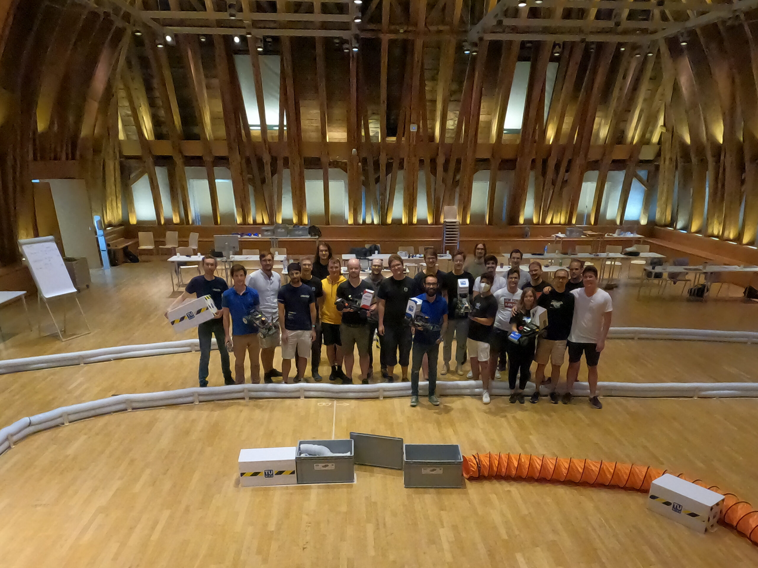 Group picture of students, guests with racing cars on the race track