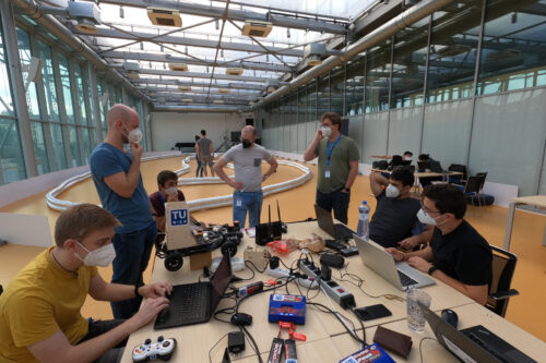 Students at table with model racing car and notebooks