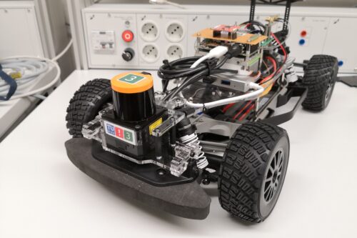 Race car based on model Fiesta standing on a table, featuring a LIDAR sensor in the front