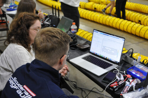 Team members are preparing the model race car and the software