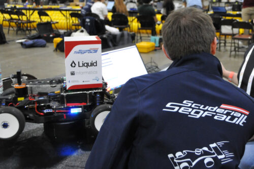 Team members are preparing the model race car and the software